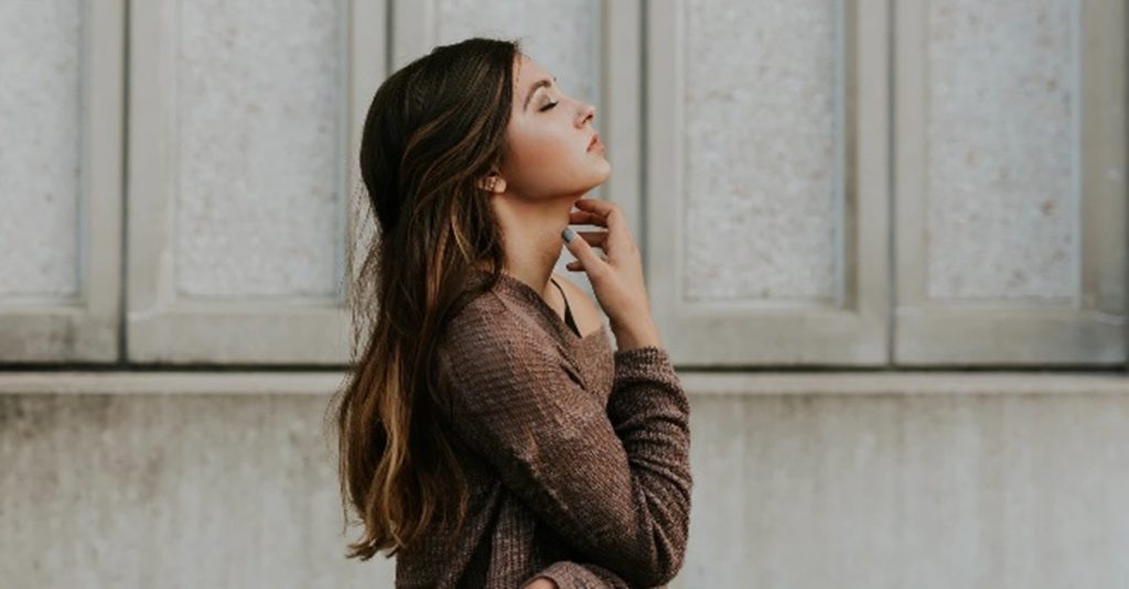 人_あごに手を当て、目をつぶって考える女性